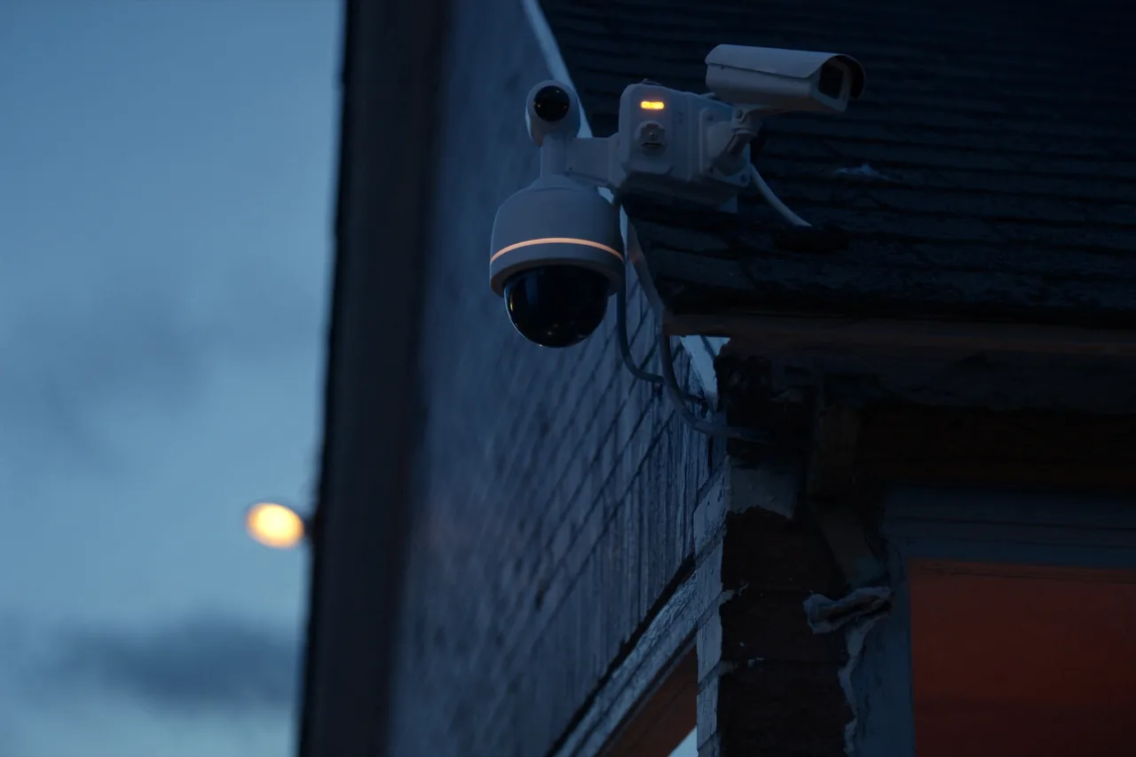 Security camera monitoring the exterior of a brick industrial building